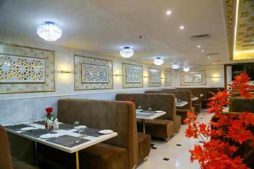 a dining room with tables and chairs and flowers at Hotel Hyderabad Grand in Shamshabad