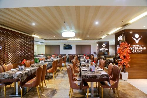 a banquet hall with tables and chairs in a room at Hotel Hyderabad Grand in Shamshabad