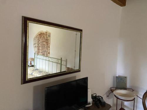 a mirror hanging on a wall with a tv at Agriturismo Al Vecio Caselo (Casa Maga) in Arsiero