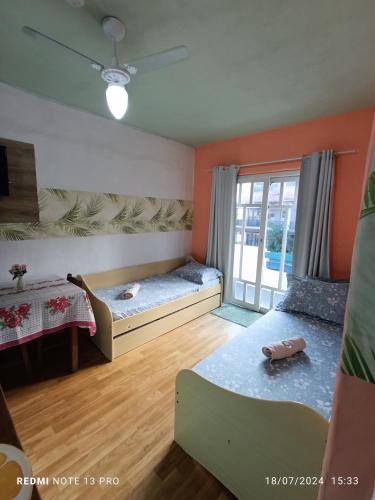 a room with two beds and a window at Residencial María in Bombinhas