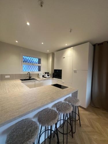 une cuisine avec deux tabourets de bar et un comptoir dans l'établissement Spacieux et Moderne T2 près du centre, à Cannes
