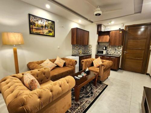 a living room with two couches and a kitchen at Subtle 1Bed In Bahria Town in Rawalpindi