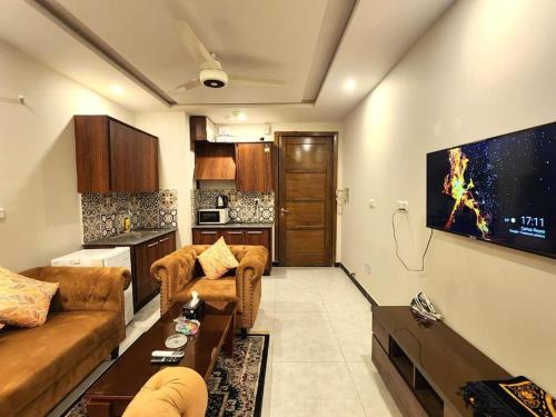 a living room with two couches and a tv at Subtle 1Bed In Bahria Town in Rawalpindi
