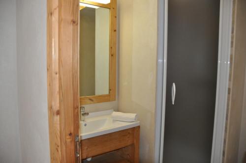 une salle de bain avec un lavabo et un miroir dans l'établissement Cortina - 51 - Appart spacieux - 10 pers, à Les Deux Alpes