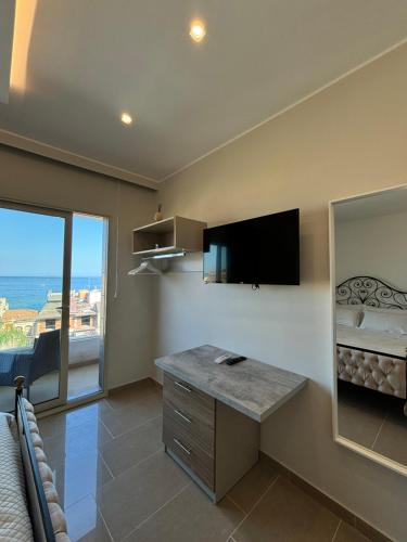 a room with a desk and a tv on the wall at IG - "Villa Don Antonio" Apartments in Giardini Naxos
