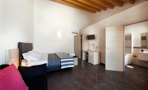 een slaapkamer met een bed en een badkamer met een bad bij Casato Licitra in Donnafugata