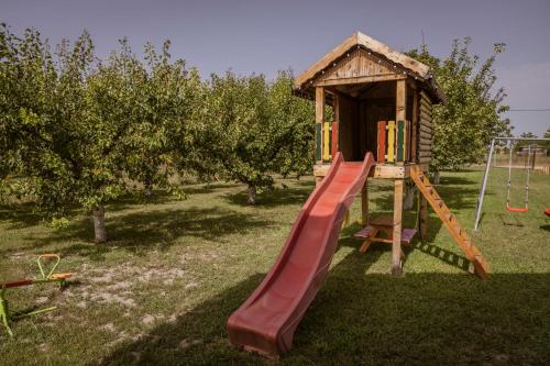 Un parque infantil con un tobogán y una casita. en Vikendica Dar, en Begeč