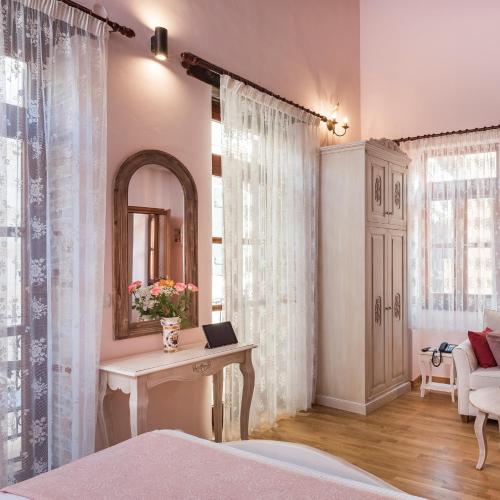 a bedroom with a mirror and a table with a mirror at Palazzo di Irene in Chania Town