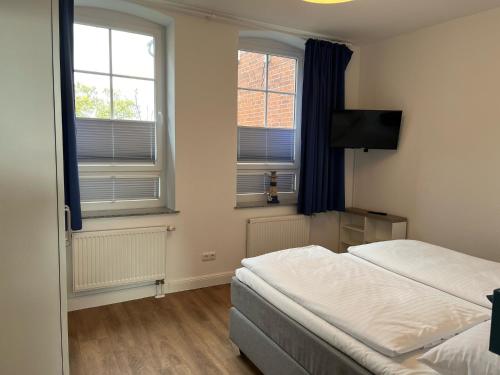 una camera d'albergo con due letti e due finestre di Ferienwohnung am Hotel am Rathaus a Schönberg