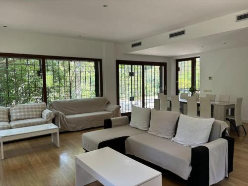 a living room with couches and tables and windows at Vivenda de luxe a Barcelona in Sant Cugat del Vallès