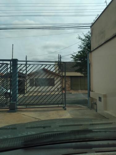 a gate in front of a building with a house at Apartamento Espaçoso Bairro Piracicamirim in Piracicaba