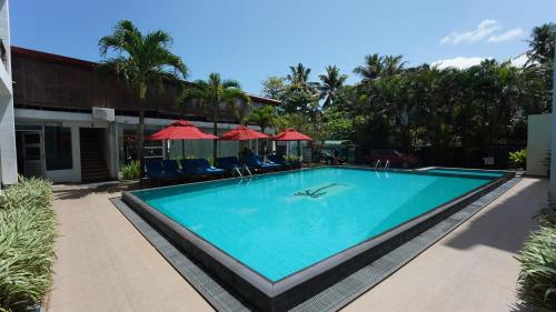 a swimming pool at a resort with chairs and umbrellas at Randiya Sea View Hotel in Mirissa