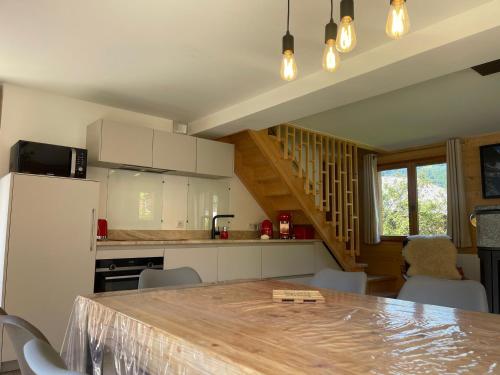 une cuisine avec une table et des chaises dans une pièce dans l'établissement Chalet rénové spacieux près des commerces, à 200m du village et du lac, navette ski-bus gratuite - FR-1-624-118, à Samoëns