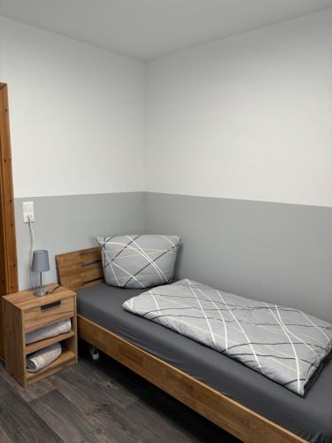 a bedroom with a bed and a night stand at Ferienwohnung Hendrich Sotterhausen 2 in Sotterhausen