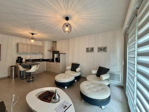 un salon avec des chaises et une table et une cuisine dans l'établissement JASMIN avec parking à 200 m du centre, à Avignon