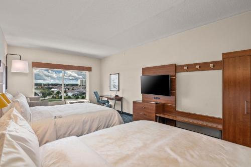 a hotel room with two beds and a flat screen tv at Holiday Inn Express & Suites Orlando- Lake Buena Vista by IHG in Orlando