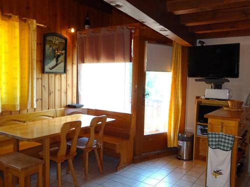 une salle à manger avec une table et une télévision dans l'établissement T2 confort 4 pers, Wi-Fi, garage, 150m commerces, 100m télécabines - FR-1-802-74, aux Gets