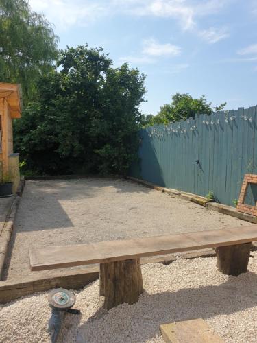 a wooden bench sitting in front of a fence at La longère in Saint-Hilaire-en-Woëvre