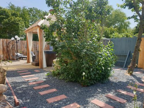 a garden with a large bush and a walkway at La longère in Saint-Hilaire-en-Woëvre