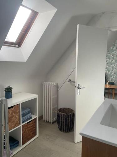 une salle de bain blanche avec un lavabo et une fenêtre dans l'établissement Joli Studio en centre-ville, à Vitré