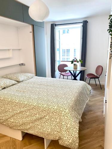 une chambre avec un lit et une table avec des chaises dans l'établissement Brand New Apartment - Rue Cler Paris, à Paris