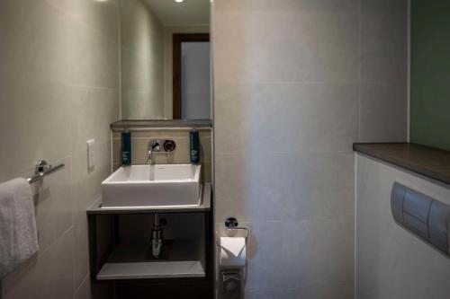 a bathroom with a sink and a mirror at DoubleTree by Hilton Leeds in Leeds