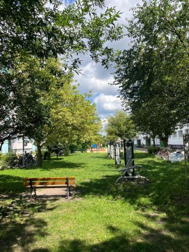 a park with a bench and trees in the grass at Sara Apartament in Turek