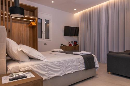 a bedroom with a bed and a couch and a tv at Irene Studios in Mastichari