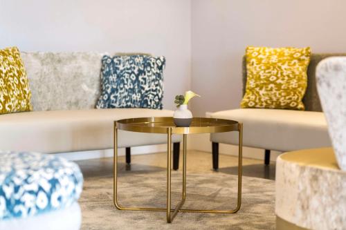 a living room with a table and a couch at NH Utrecht in Utrecht