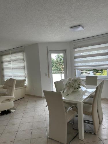 a dining room with a white table and chairs at Neubau Schmidt 4 Zimmer KASSEL Premium Qualität keine Parkplatz gebühren in Lohfelden