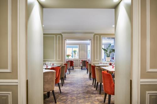 un comedor con mesas y sillas en Hotel Westminster, en París