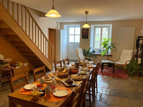 een eetkamer met een lange tafel met stoelen bij Les Chambres d'Eponine in Saints-Geosmes