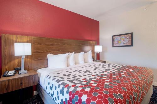 a hotel room with a bed and a red wall at Econo Lodge Inn & Suites Foley-North Gulf Shores in Foley