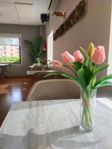 a vase of pink flowers sitting on a table at Hostal Buenos Aires in Tremp