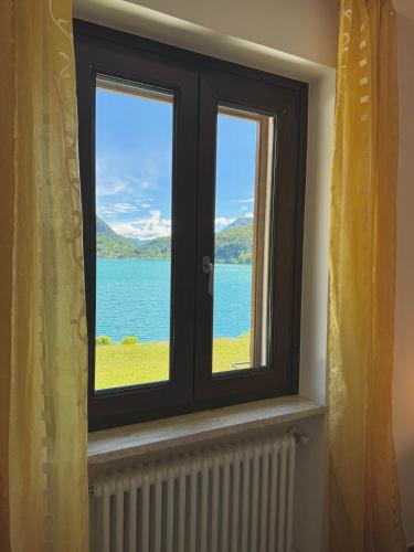 a window with a view of the water at Serena Charme View in Mezzolago
