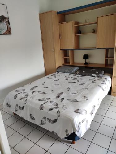 une chambre avec un lit avec une couverture dessus dans l'établissement Au pti Logis Du Summer 2, à Brioude