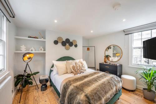a bedroom with a bed and a television in it at Pottter's Perch - Covent Garden - By Frankie Says in London