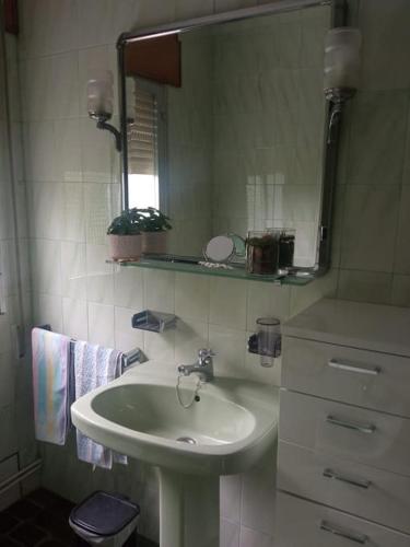 a bathroom with a sink and a mirror at Acogedora casita de campo in Bóveda