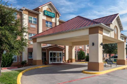 a hotel building with a sign on top of it at Quality Suites Addison-Dallas in Addison