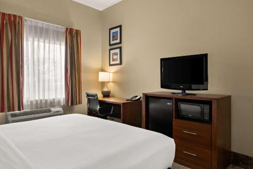 a hotel room with a bed and a flat screen tv at Comfort Inn Ogden near Event Center in Ogden