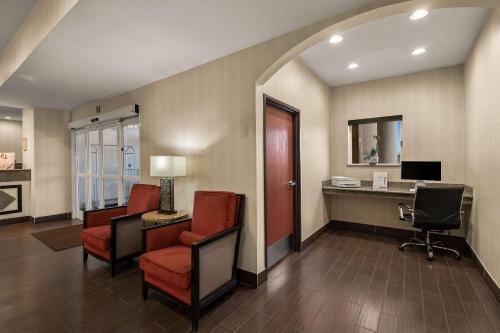 a lobby with chairs and a desk with a computer at Comfort Inn Ogden near Event Center in Ogden