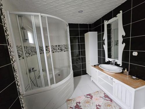 ein Badezimmer mit Dusche, Badewanne und Waschbecken in der Unterkunft Denize Yakın Geniş Villa in Hurmaköy