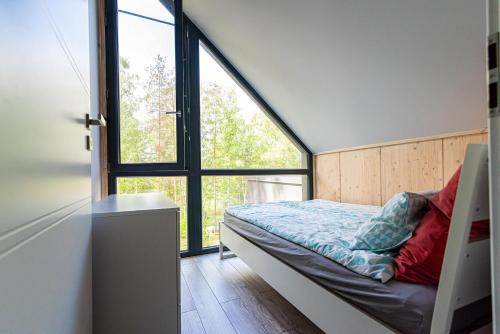 a bedroom with a bed and a large window at Szklany Dom nad Łąkami in Zbiczno