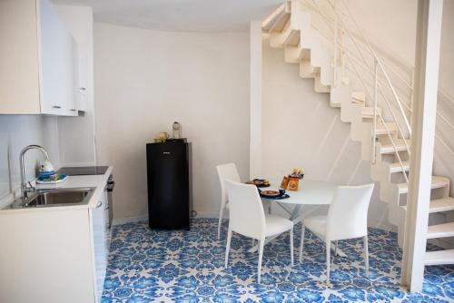 a kitchen with a table and chairs and a staircase at River Song - Vietri sul Mare in Vietri sul Mare