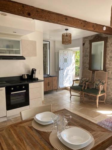 une cuisine avec une table avec deux assiettes dessus dans l'établissement Le Logis des Remparts Coeur de la Cité médiévale, Jardin privé, à Carcassonne