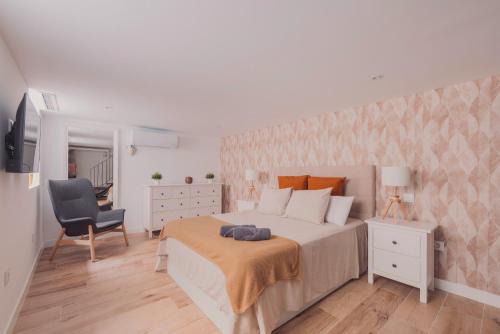 a bedroom with a large bed and a chair at Apartamento El Rastro - Centro de Madrid in Madrid