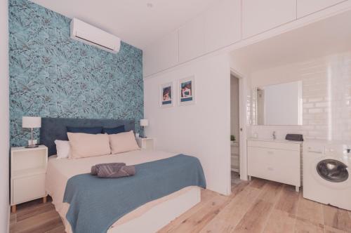 a white bedroom with a bed and a bathroom at Apartamento El Rastro - Centro de Madrid in Madrid