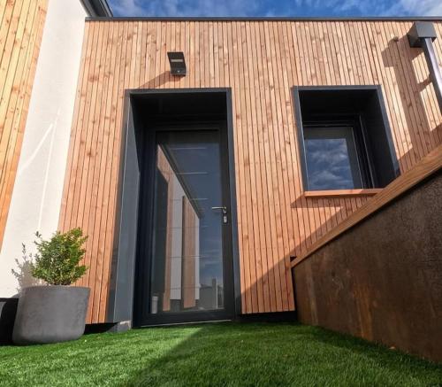 a building with two large doors on the side of it at Cocon indépendant avec SPA in La Jarrie