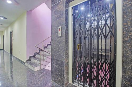 a hallway with a metal door with purple walls at Super Hotel O SRI NIRVANA PRIDE in Hyderabad