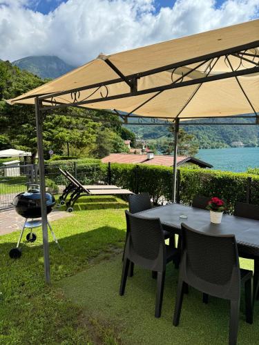 a table and chairs under an umbrella with a helicopter at Serena Charme Garden in Ledro